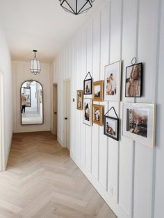 a hallway with white walls and pictures on the wall