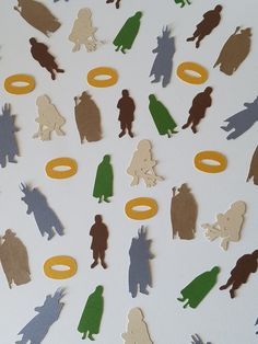 many different cutouts of people and animals on a white surface with yellow rings in the middle