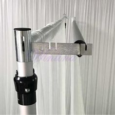 a close up of a metal pole on a curtain rod with a black and silver handle