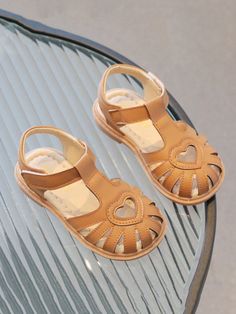 Add a touch of sweetness to your little girl's wardrobe with these adorable heart-cutout leather sandals. 	Perfect for any occasion, these sandals are designed to keep her comfortable and stylish all day long. 	Featuring a cute heart cutout and stylish detailing, these sandals are perfect for your little fashionista. 	The adjustable Velcro strap makes it easy for your little one to put on and take off these sandals by herself. 	Let your little girl step out in style with these sweetheart sandals. 	Ideal for playdates, family gatherings, or a day out in the sun, these sandals are sure to become her go-to pair for every occasion. Cute Brown Closed Toe Sandals, Cute Leather Sandals With Round Toe, Cute Leather Sandals For Spring, Cute Brown Sandals For Spring, Cute Brown Summer Sandals, All American Girl, Girls Pageant Dresses, Communion Dresses, Cute Heart