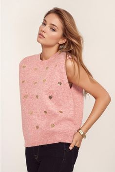 Introducing our Sleeveless Sweater in Pink with Silver Sequin Hearts – a cute and romantic addition to your wardrobe. This charming pink sweater features a delightful heart print in silver sequins, adding a touch of whimsy to your outfit.  Designed with a classic crew neckline, this sleeveless style offers a relaxed fit for both comfort and style. The soft knit fabric, crafted from a blend of 60% Polyester, 30% Polyamide, and 10% Wool, ensures a cozy feel against your skin.  The silver sequin hearts scattered across the sweater create a playful and eye-catching look, making it perfect for adding a romantic touch to your ensemble. Pair it with a black or white blazer for a chic and sophisticated outfit.  For sizing reference, the model is wearing size U, with measurements 33-24-35 and a hei Midi Denim, Balloon Sleeve Top, Denim Midi Skirt, White Blazer, Silver Sequin, Sleeveless Sweater, Pink Shirt, Pink Sweater, Heart Print