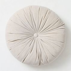 a white round pillow on the wall