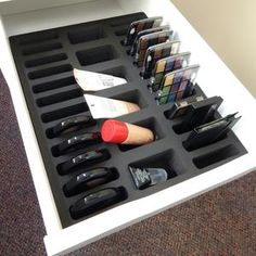 an open drawer with various makeup and other items in it on the carpeted floor