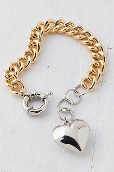 Mixed in gold and silver, this chunky chain bracelet is trimmed with an oversized heart charm. Features Metal heart chain bracelet Chunky chain bracelet Mixed metal design Polished metal heart charm Adjustable closure Content + Care Mixed metal Avoid contact with water Imported Size Dimensions: 7.5" l | Metal Heart Chain Bracelet in Assorted, Women's at Urban Outfitters Trendy Gold Heart Bracelet With Chain, Gold Heart Charm Bracelet With Chain, Trendy Metal Bracelets With Heart Charm, Trendy Heart-shaped Chain Bracelets, Trendy Heart-shaped Chain Bracelet, Metal Heart Bracelet With Adjustable Chain, Gold Metal Chain Bracelet With Heart Charm, Gold Chain Bracelet With Heart Charm, Metal Heart Charm Bracelet With Adjustable Chain