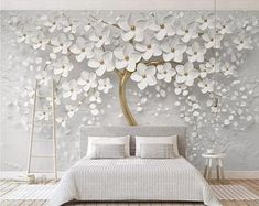 the bedroom is decorated with white flowers on the wall, and there are two tables in front of the bed