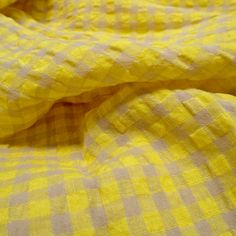 a yellow and white checkered comforter on a bed