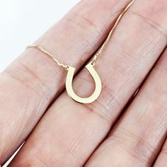 This stunning horseshoe gold necklace is a perfect symbol of good luck and charm. The pendant is crafted from high-quality 14k gold and features a beautifully designed horseshoe with intricate detailing that catches the eye. The pendant hangs on a dainty yet sturdy gold chain that complements the pendant's design, creating an elegant and timeless piece of jewelry. This necklace is perfect for adding a touch of equestrian style to any outfit, and is a must-have for any horse lover, cowgirl, or co Horseshoe-shaped Jewelry With Adjustable Chain, Gold Horseshoe Jewelry With Adjustable Chain, Gold Horseshoe Necklace For Good Luck, Personalized Horseshoe Necklace For Gift, Gold Horseshoe Charm Necklaces As Gift, Gold Horseshoe Charm Necklace As Gift, Gold Horseshoe Charm Necklace For Gift, Gold Horseshoe Necklace For Gift, Yellow Gold Horseshoe Necklace Gift