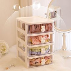 three drawers with baby items in them on a white countertop next to a mirror