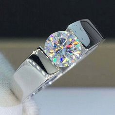 a diamond ring sitting on top of a white cloth