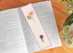 an open book with some flowers on it