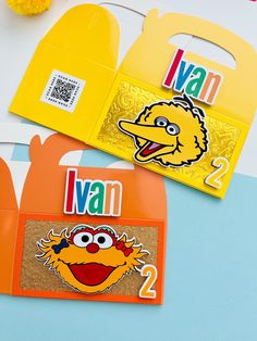 two sesame street magnets on top of each other next to an orange bag with the number 2