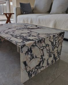 a marble coffee table in front of a couch