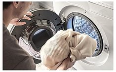 a man is looking at his clothes in the washing machine