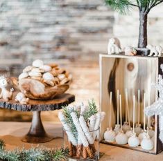 a table topped with lots of desserts next to a christmas tree