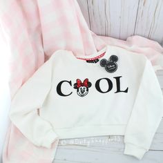 This Cropped Sweatshirt Features A "Cool" Graphic On The Front W/ One Of The "O's" Detailed As A Sequin Minnie Mouse. The Inside Neck Has Minnie Mouse And Hearts Logo Tape Running Across The Back. This Simple Sweatshirt Has All The Little Details In Mind. The Inside Of This Sweatshirt Is A Buttery Soft Brushed Texture. 65% Polyester, 35% Cotton. Disney X Primark All Orders Are Packaged With And Are Shipped Out Asap! Questions? Leave Us A Comment! We Are More Than Happy To Help! New To Poshmark? Fall Cotton Mickey Mouse Tops, Fall Mickey Mouse Cotton Tops, Cool Cotton Winter Tops, Cool Cotton Tops For Winter, Cute Minnie Mouse Tops For Fall, Playful Long Sleeve Minnie Mouse Top, Cute White Sweatshirt With Cartoon Print, Cute White Winter Tops, Cute Mickey Mouse Cotton Sweatshirt