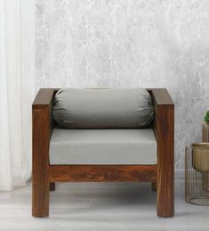 a wooden chair sitting in front of a wall with a plant on top of it