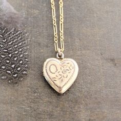 This vintage locket is engraved with a floral design on the front; the reverse is plain.  The gold filled heart, hallmarked 10k gf, opens revealing two compartments in which to place your favorite photos.  The locket hangs from a new 14k gold filled cable chain accented with tiny white pearls at the clasp.    Locket 24x21mmNecklace length 18" (45cm)✦All of our vintage lockets ship with complimentary insurance✦✤Our entire selection of lockets can be found here✤http://www.etsy.com/shop/LexiandGem? Antique Rose Gold Jewelry For Ceremonial Occasions, Vintage Rose Gold Jewelry With Intricate Design, Heirloom Jewelry For Valentine's Day, Brass Heart Charm Necklace For Wedding, Wedding Jewelry Medallion With Heart Charm, Valentine's Day Gold Necklace With Intricate Design, Valentine's Day Yellow Gold Jewelry With Intricate Design, Yellow Gold Heart Pendant Jewelry With Intricate Design, Intricate Heart Pendant In Yellow Gold