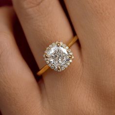 a woman's hand with a diamond ring on top of her finger and an engagement band