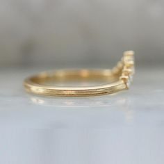 Why I Love It: This delicate tiara band makes a wonderful addition to your stack or on its own. Seven high quality white round brilliant cut diamonds are set into your choice of golds, and is perfect to pair with low profile rings. The Details: Available in: 14k Yellow Gold, 14k White Gold, 14k Rose Gold & 18k Peach Gold® Available in 18k & Platinum By Request Approximately .19 Carats of GH/VS White Round Brilliant Cut Diamonds Band Width is Approx. 1.80 mm Made to order in your size, please all Yellow Gold Moissanite Half Eternity Stackable Rings, Timeless Adjustable Diamond Ring With Round Band, Minimalist Diamond Band With Single Cut Diamonds, Single Diamond Anniversary Bands, Anniversary Diamond Band With Single Diamond, Anniversary Bands With Single Diamond, Delicate Diamond Ring With Round Band, Moissanite Stackable Rings With Single Cut Diamonds, 14k Gold Half Eternity Diamond Ring With Open Band