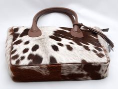 Authentic speckled cowhide shoulder purse for daily use. Ideal rodeo gift with western or southern flair. - Free Shipping: Enjoy complimentary shipping on all cowhide fur purses. - Premium Craftsmanship: Crafted with premium hair-on cowhide for a luxurious feel. - Double-Sided Fur: Cowhide fur adorns both sides of the purse, adding a touch of sophistication. - Durable Handles: Elegant leather handles ensure durability for everyday use. - Interior Features: Cotton/satin lining with inside and zipper pockets for organized storage. - Exquisite Craftsmanship: Meticulously crafted with exquisite craftsmanship in a structured design. - Dimensions: Generous size measuring 15' L x 13' H x 5' W to accommodate your essentials. - Versatile Tote: A versatile tote shoulder handbag suitable for any occa Essential Fashion Pieces, Western Style Interior, Rodeo Gifts, Cowhide Purse, Fur Purse, Cowhide Bag, Organized Storage, Rodeo Fashion, Structured Design