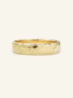 a yellow gold wedding ring on a white background