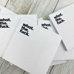 five pieces of white paper with black words on them sitting next to each other in front of a wooden table