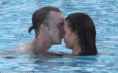 a man and woman kissing in the water