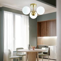 a dining room table and chairs in front of a window