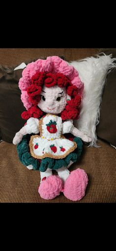 a crocheted doll is sitting on a couch