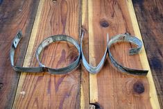 the word love is made out of horseshoes on a wooden table with wood planks