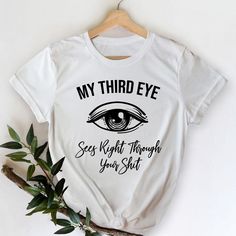 This stylish unisex 'My Third Eye Sees Right Through Your Shit' white t-shirt fits like a well-loved favorite. Super soft cotton and excellent quality print make one fall in love with it over and over again.It feels soft and lightweight, with the right amount of stretch. It's comfortable and flattering for both men and women.This t-shirt is a perfect gift for anyone who has a sense of humor and loves spirituality, yoga, and meditation. 100% soft spun cotton 4.4-ounce and 30 singles 1x1 rib knit Spiritual T Shirts, Funny White T-shirt With Slogan, Funny White Slogan T-shirt, Funny Slogan White T-shirt, White Graphic Tee With Funny Text, White Funny Shirt With Text Print, Funny White Shirt With Text Print, White Funny Text Print Shirt, White Casual Ring-spun Cotton Shirt