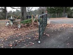 there is a large metal gate in the yard with leaves on the ground around it