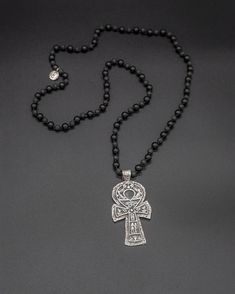 Immerse yourself in the realm of ancient mysteries with this multi-symbol silver ankh pendant. Hanging delicately from a chain crafted from lava stone and black tourmaline. The ankh serves as a symbolic talisman, symbolizing rebirth and eternal life. The chain is 71 cm long [app 28 in long] Black Symbolic Cross Pendant Necklace, Symbolic Ankh Jewelry For Meditation, Black Symbolic Jewelry With Large Pendant, Spiritual Ankh Shaped Metal Jewelry, Black Symbolic Cross Pendant Jewelry, Symbolic Black Jewelry With Large Pendant, Symbolic Black Cross Pendant Jewelry, Sterling Silver Ankh Amulet Jewelry, Ankh Shaped Black Metal Necklace