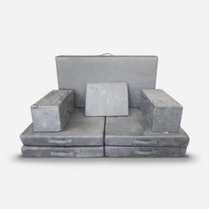 a couch made out of concrete blocks with four different sized boxes on the top and bottom