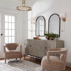 a living room with two chairs and a dresser