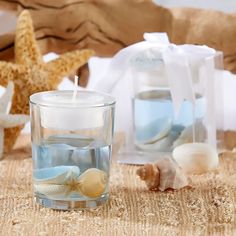 a candle that is sitting on a table next to some seashells and starfish