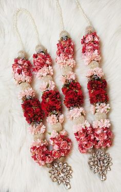 three necklaces with flowers on them are laying on a furnishing area next to a white rug