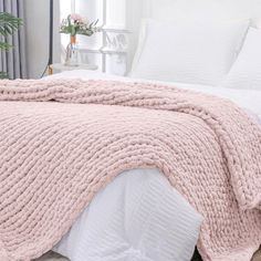 a bed with a pink blanket on top of it