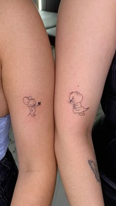 two people with matching tattoos on their legs, one has a small mouse and the other has a heart