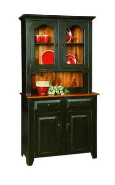 a green china cabinet with red plates on it