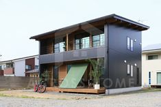 a house that is made out of two story houses and has a ramp leading up to the front door