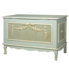 an antique chest with flowers on the front and sides, painted in pale blue color