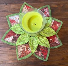 a candle sits on top of a quilted flower