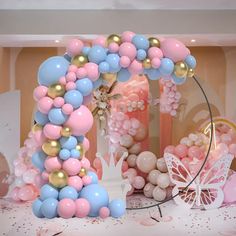 the balloon arch is decorated with pastel pink, blue and gold balloons for a princess themed birthday party