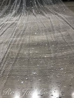 the bride's wedding dress is covered with veils and snowflakes as she walks down the aisle