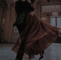 a man and woman are dancing in an old building