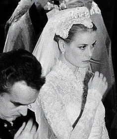 black and white photograph of a bride and groom with their hands on their foreheads