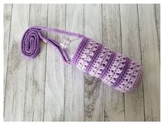 a purple crocheted bag with a light bulb attached to it on a wooden floor