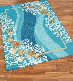 a blue rug with shells and seaweed on it