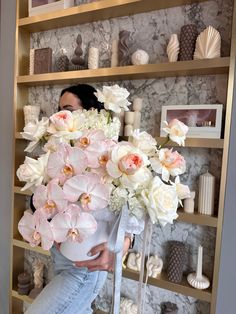 a woman is holding a large bouquet of flowers